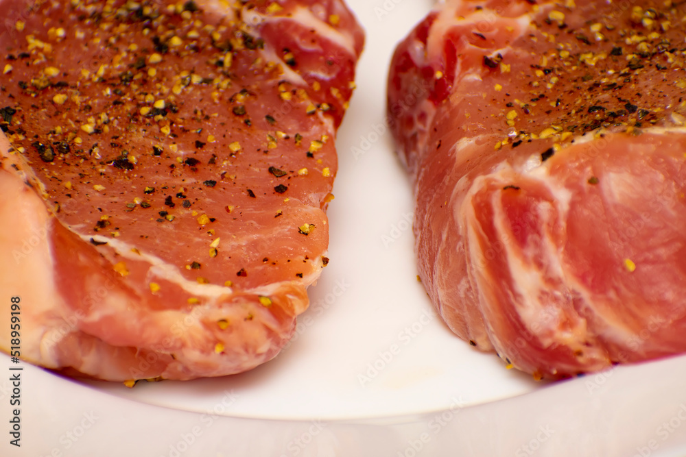 raw pork steak on a white plate raw pork steak on a white plate