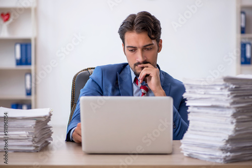 Young male employee and too much work in the office