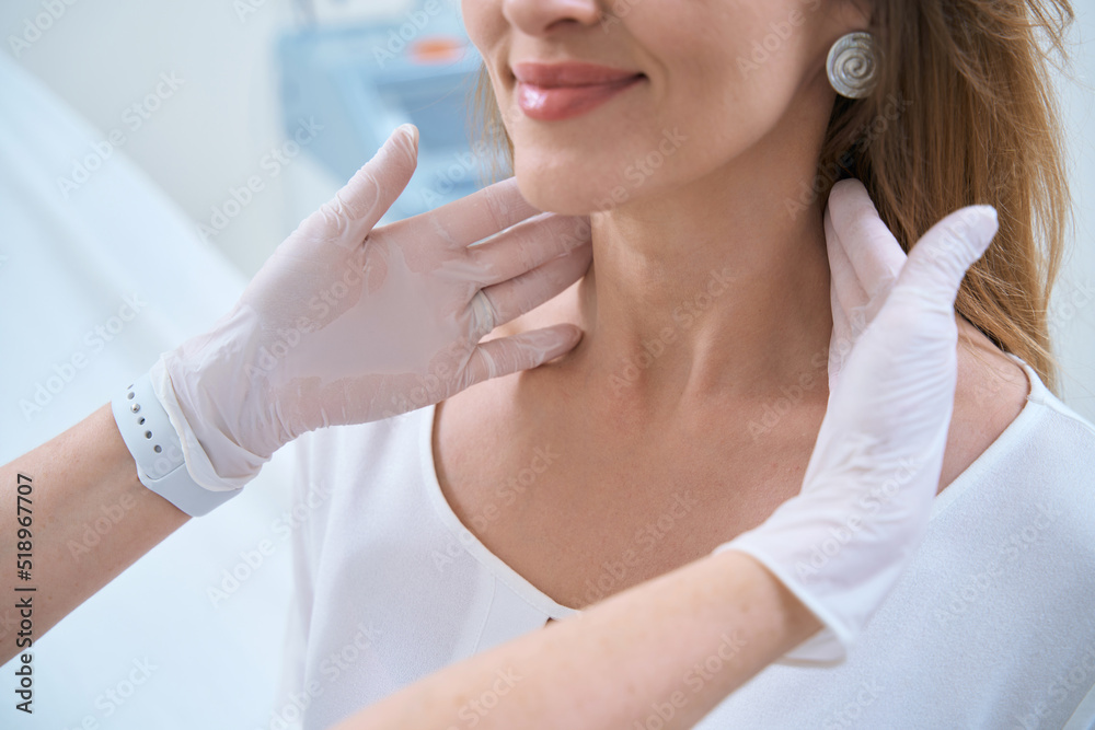 Dermatologist with hands in gloves touches the patient neck, close-up Dermatologist with hands in gloves touches the patient neck, close-up