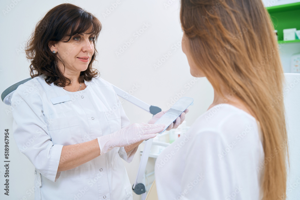 Two women talking in a medical and cosmetology center Two women talking in a medical and cosmetology center