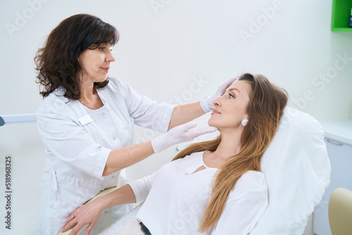 Dermatologist examines the skin of the patient face