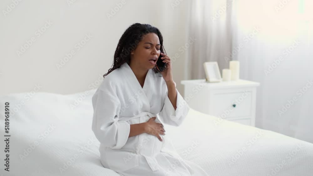Emergency call. Unhappy pregnant african american woman suffering from belly pain, calling to doctor for urgent help Emergency call. Unhappy pregnant african american woman suffering from belly pain, calling to doctor for urgent help