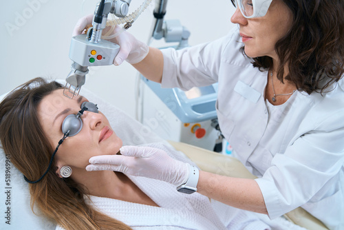 Woman undergoes a procedure for laser removal of neoplasms in the forehead
