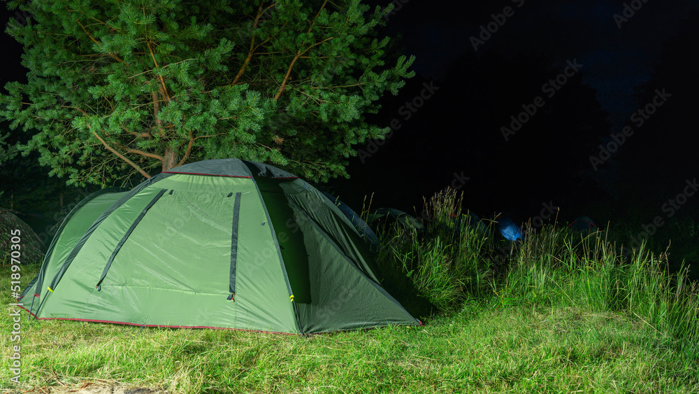 Tents camping area. Camping and tent. Tourist tent stands under the tree at night. Travel and adventure concepts.