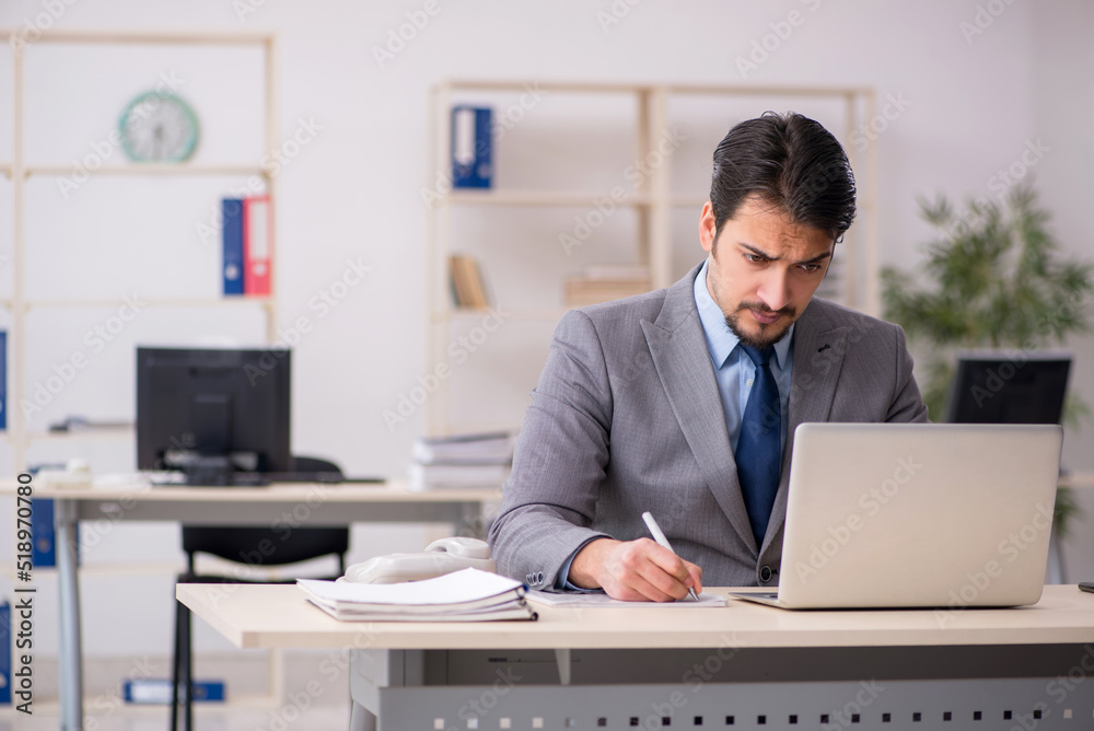 Young male employee working in the office Young male employee working in the office