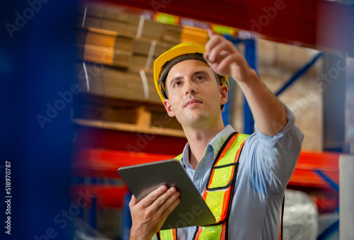 Warehouse worker with digital tablet checking inventory in warehouse, Worker working in factory warehouse