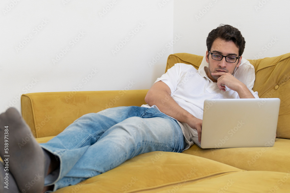 Young businessman working on laptop at home. Distant work concept Young businessman working on laptop at home. Distant work concept