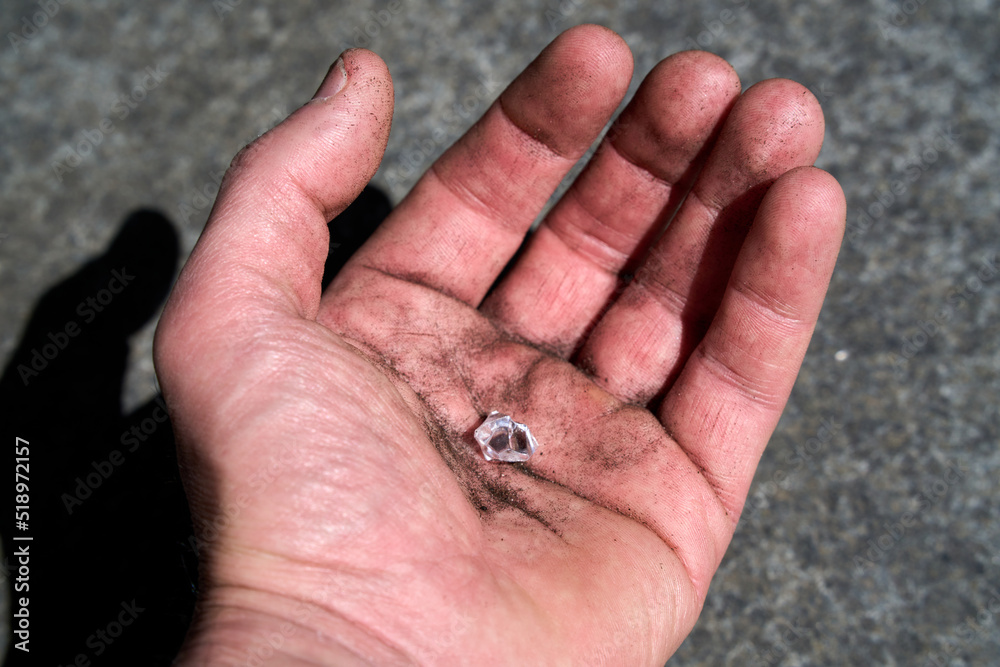 Hand with a simulated diamond pretending to have been found on earth