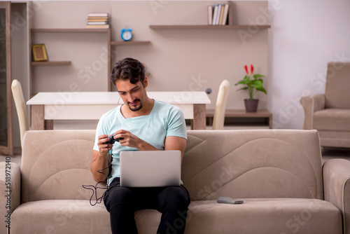 Young man playing joystick games at home