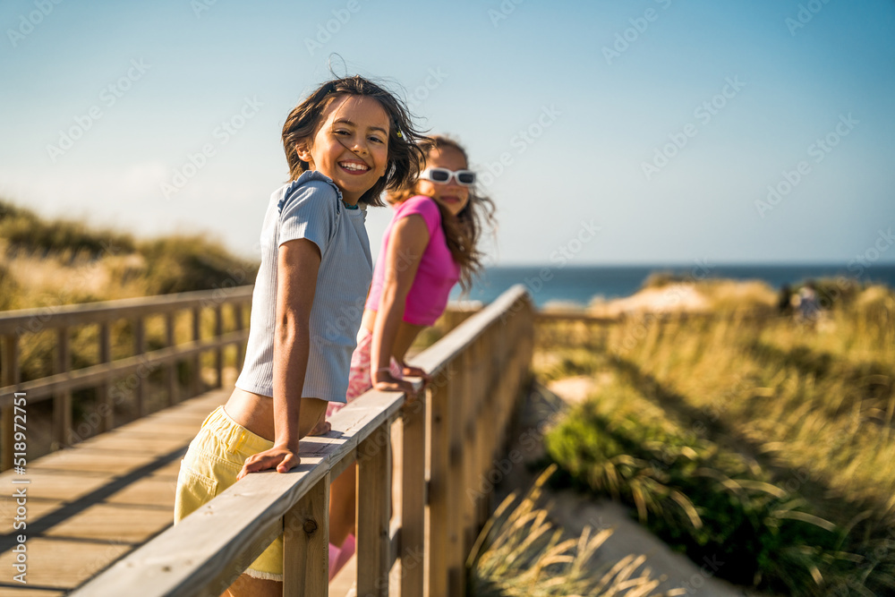 Kid girls looking at the camera with happy faces while enjoying of the summer vibes