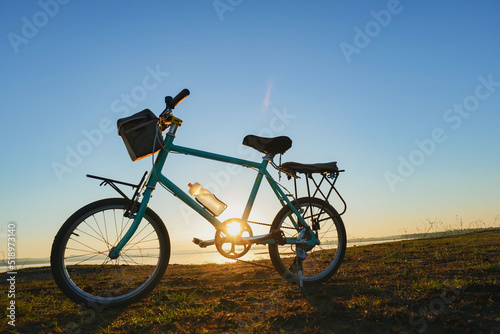 Fototapeta Naklejka Na Ścianę i Meble -  Bicycle in the morning sunshine by the lake.
