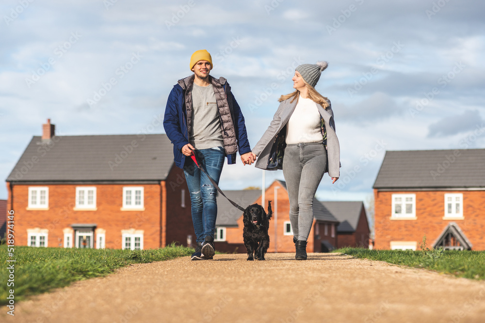 Happy couple walking the dog on a sunny autumn day