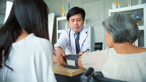 Male doctor measuring the patient's blood pressure Senior woman in the hospital.