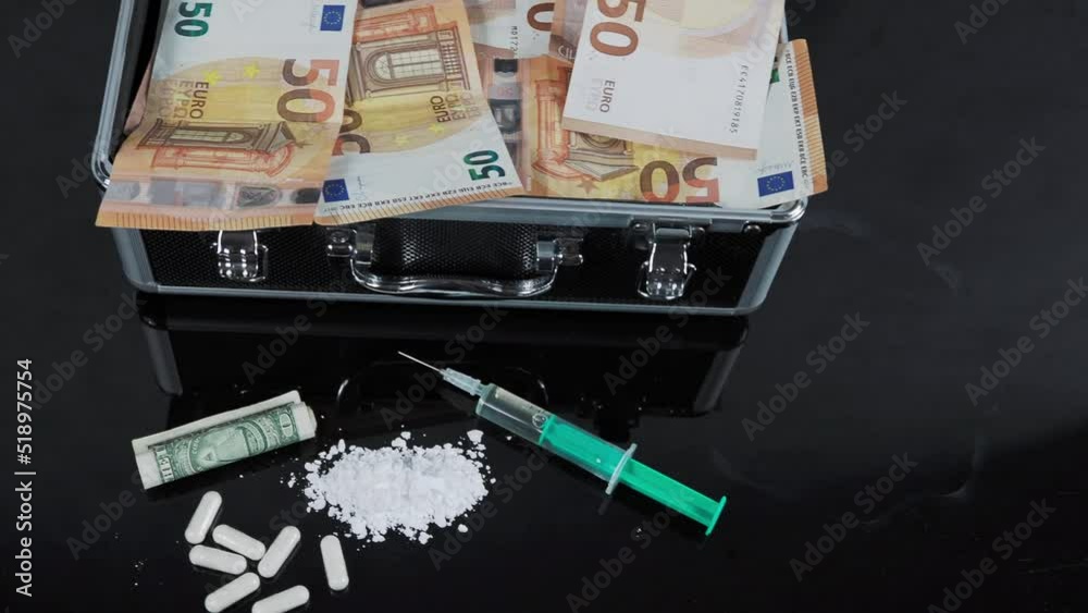 Money and drugs on a black glass table. Money, syringe and drugs. Money and drugs on a black glass table. Money, syringe and drugs.