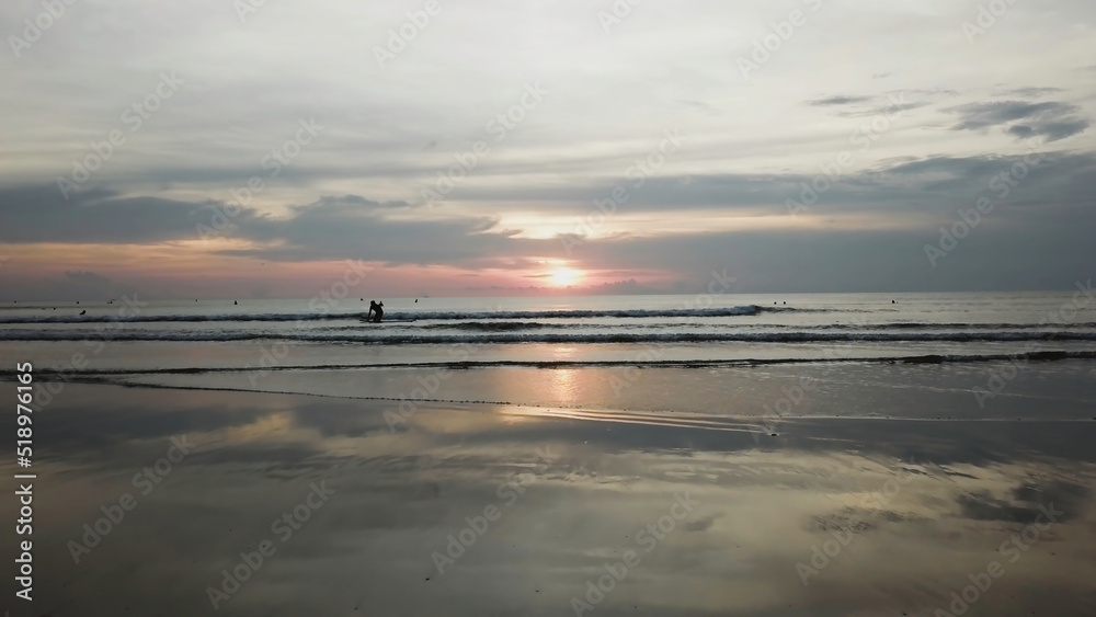 Golden sunset on the ocean shore and sand. Video. Ocean waves on the shore on sunset