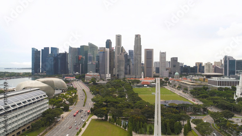 Singapore city skyline along Singapore River, beautiful green grass and the road. Shot. Aerial for Singapore coastal skyline, high rise buildings and green park.