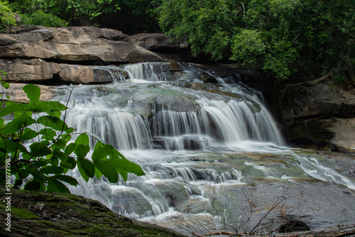 small waterfall In the midst of nature, blurry branches