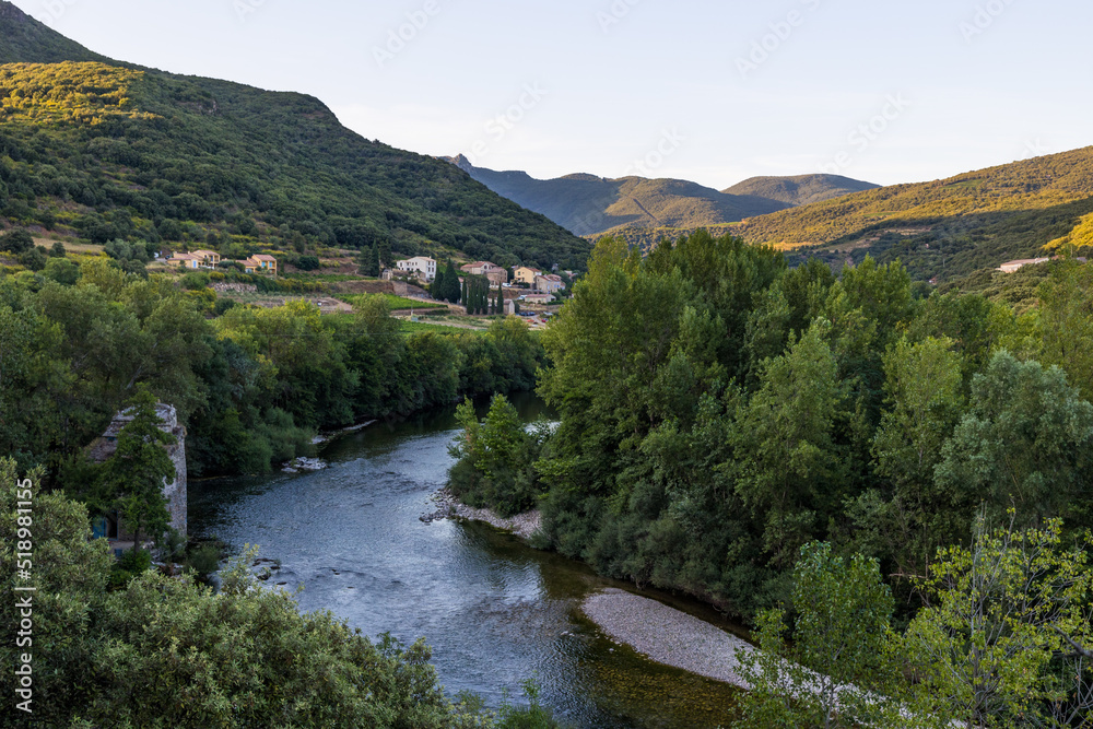 Vue au coucher du soleil sur le hameau de Ceps au bord de l'Orb dans Parc naturel régional du Haut-Languedoc Vue au coucher du soleil sur le hameau de Ceps au bord de l'Orb dans Parc naturel régional du Haut-Languedoc