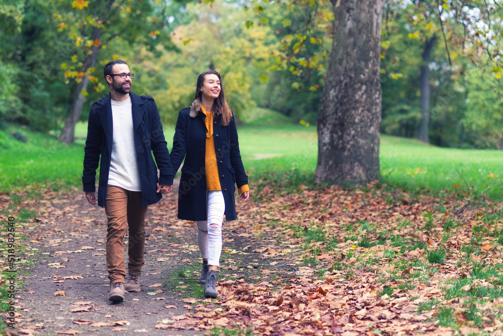 Smiling young couple in love having fun in the park on a beautiful autumn day Smiling young couple in love having fun in the park on a beautiful autumn day