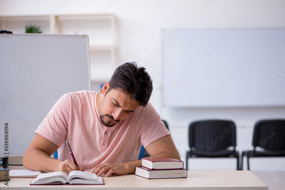 Young male student preparing for exams in the classroom Young male student preparing for exams in the classroom