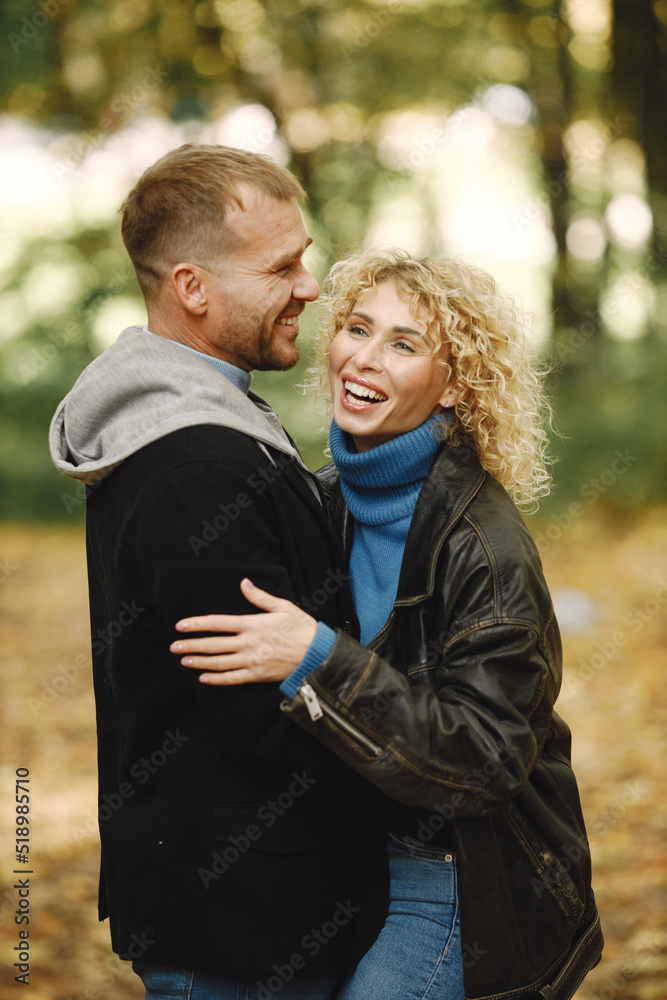 Romantic couple standing in a forest, hugging and posing for a photo Romantic couple standing in a forest, hugging and posing for a photo