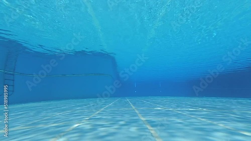 Underwater shot of an clean empty inside of the swimming pool. blue water background with copy space..