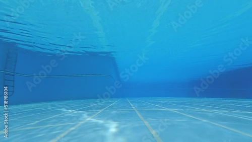 Underwater shot of an clean empty inside of the swimming pool. blue water background with copy space..