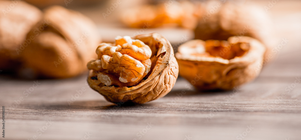 Obraz premium Walnuts kernels on wood desk with detail background, walnut on wood kitchen underlay.