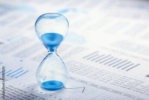 Best time for investment. Hourglass, financial charts and calculator.