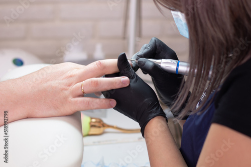 Nail master holding male hand with manicure in beauty salon 