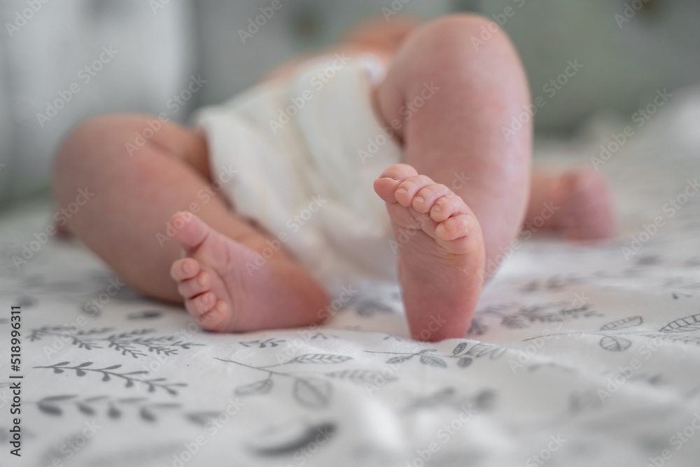 Small children's feet are lying on the bedspread. Cute newborn concept Small children's feet are lying on the bedspread. Cute newborn concept