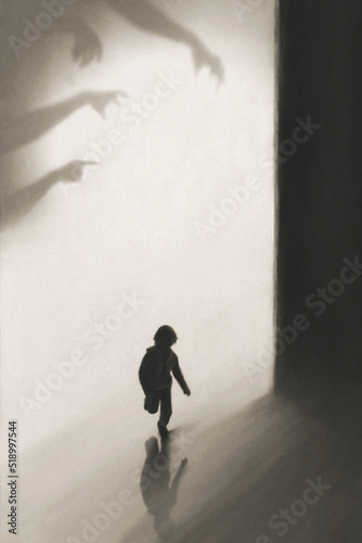 young boy runs away frightened by shadows of hands on the wall who want to catch him photo