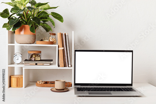 Empty laptop screen, desktop organizer with desk shelves and office supplies. Back to school, home office, begining of studies concept. Mockup, template