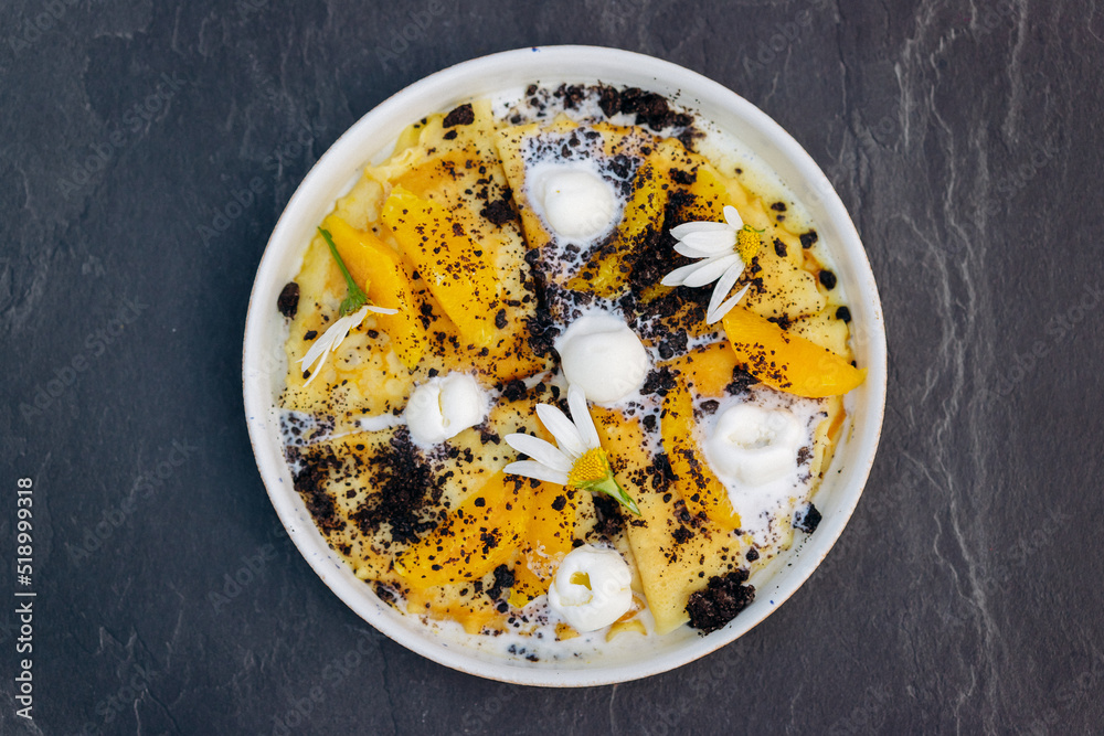 Sweet pancakes with ice cream, chocolate and orange served on white plate. Healthy and tasty breakfast