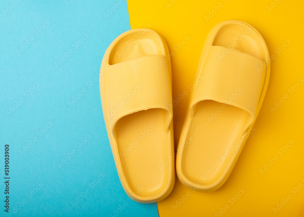 Stylish rubber slippers on a blue background.Replacement shoes.Beach shoes.Copy space. Place for text. Stylish rubber slippers on a blue background.Replacement shoes.Beach shoes.Copy space. Place for text.