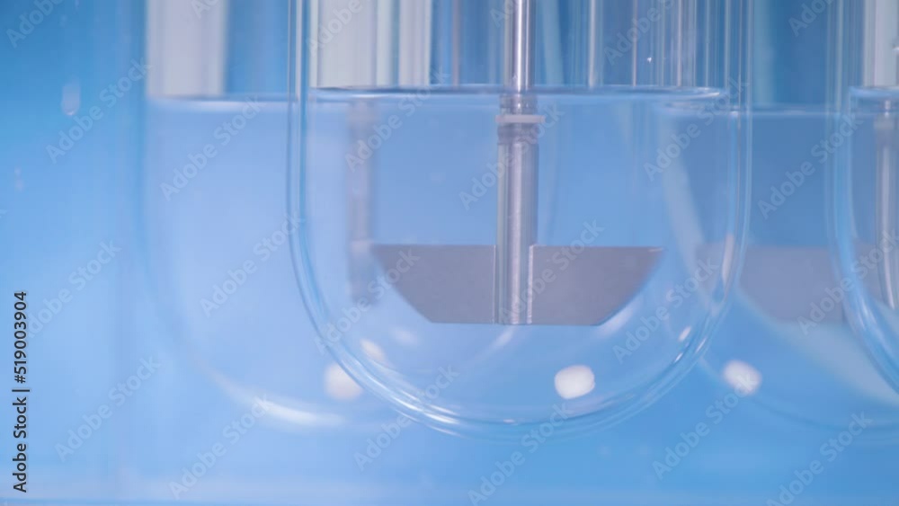 Experiments at the Lab. Sliding Shot of a Dissolution Apparatus Testing Medication Pills Dissolving Tablets in Liquid.Laboratory Routine.