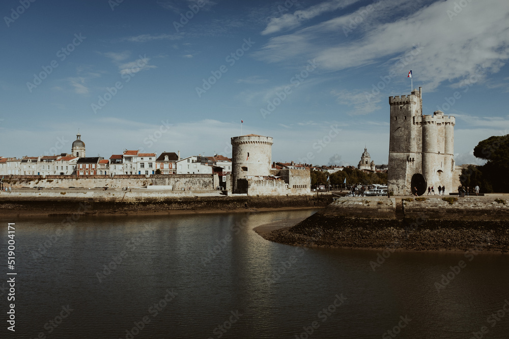 view to the castle and towers of la rochelle in france on the atlantic coast with a river and blue sky