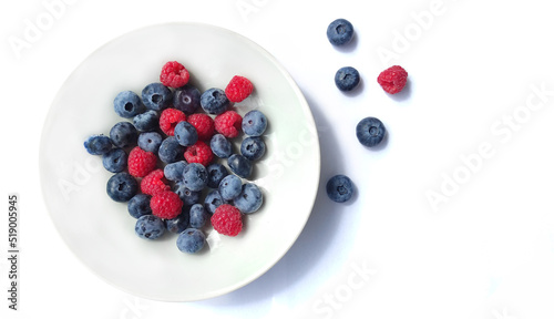 Wallpaper Mural Juicy blueberries and raspberries in a plate close-up on a white background Torontodigital.ca