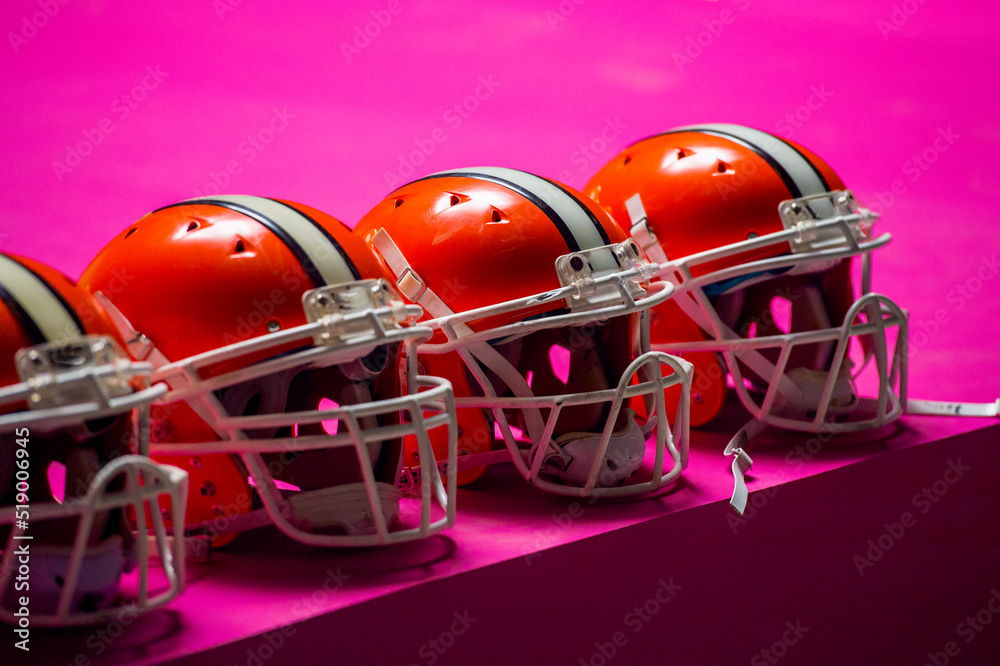 american football players helmets on pink background isolated without people .sport team protection concept.