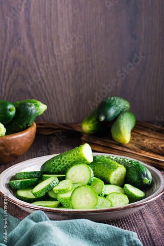 Ripe sliced cucumbers on a plate on the table. Organic diet food. Vertical view