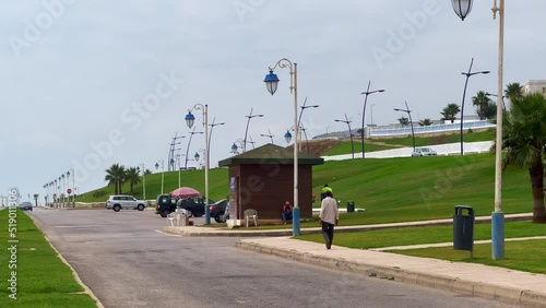 Man walking on the street alongside the seaside photo