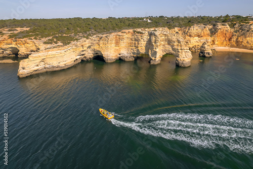 Tourist speed boat riding along a beautiful coast in Algarve province, Portugal