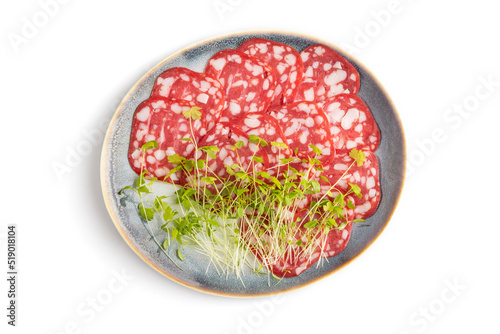 Slices of smoked cervelat salami sausage with spinach microgreen isolated on white, top view, close up.