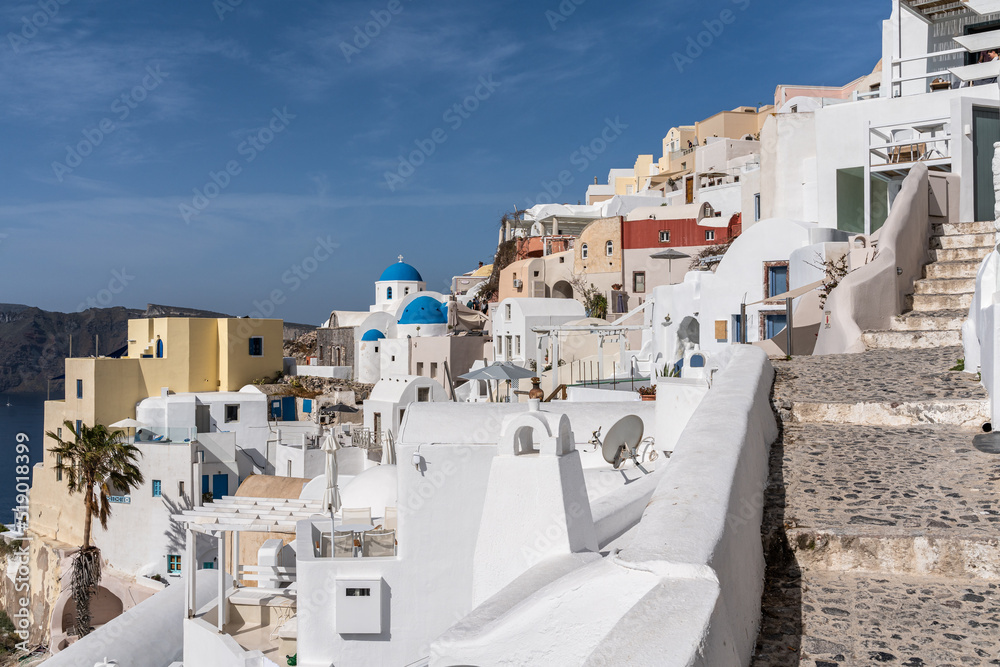View of Oia village in Santorini with traditional white houses and blue domes churches, Greece