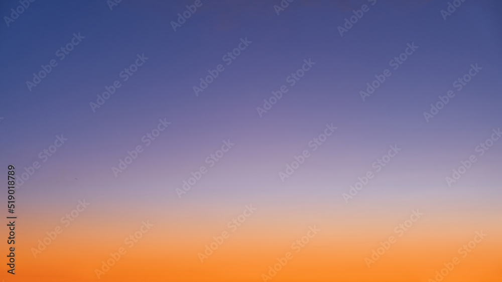 Gradient of orange-blue evening sky without clouds at sunset