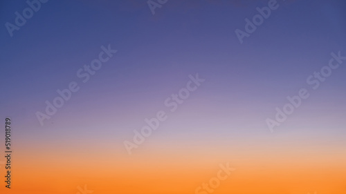 Gradient of orange-blue evening sky without clouds at sunset