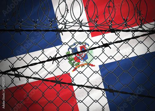 Dominican Republic flag behind barbed wire and metal fence