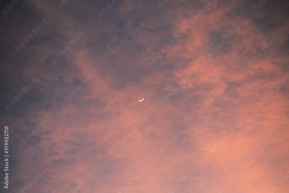 clouds at sunset with crescent moon