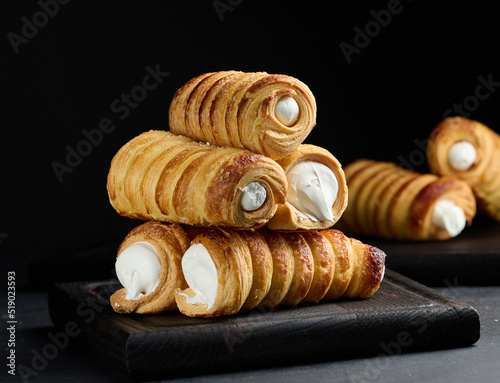 Baked tubules with whipped protein cream on a wooden board
