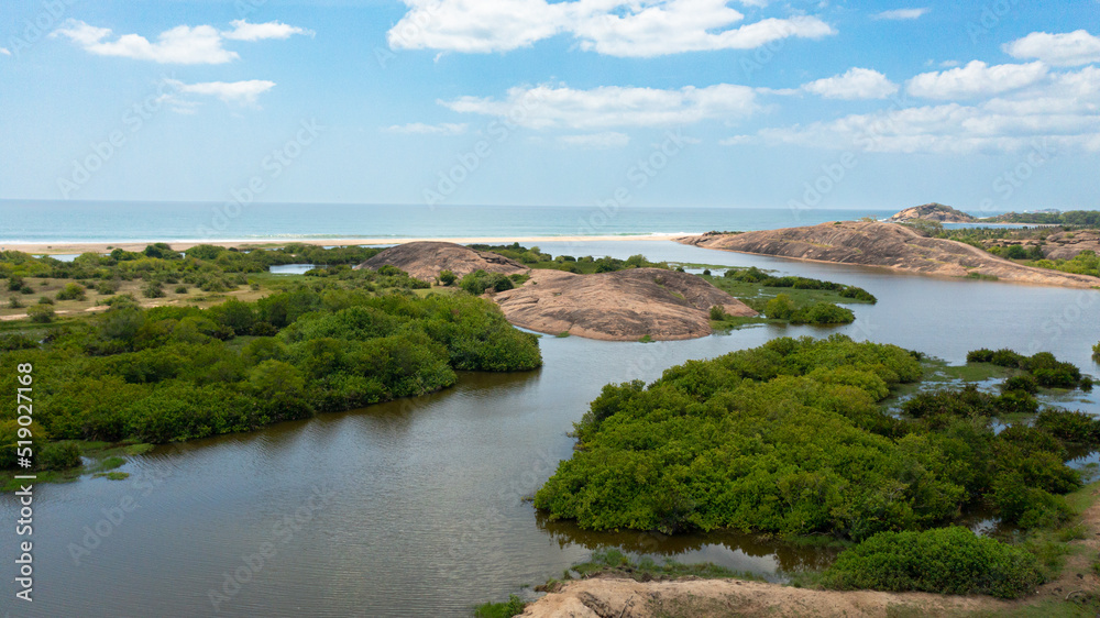 A lake with tropical vegetation and a coastline with a beach. Arugam Bay, Sri Lanka.